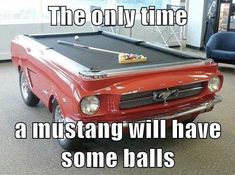 an old red truck with a pool table in the front and words above it that read, the only time a mustang will have some balls