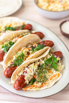 three tacos on a plate with other food items