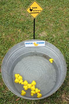 a metal bowl with yellow rubber ducks in it and a duck crossing sign on the side