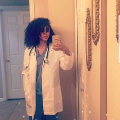 a woman in a white lab coat taking a selfie