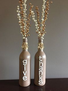 two vases with flowers in them sitting on a table next to each other, one has the word love written on it