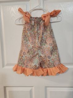 This listing is for an adorable little romper.  It is made out of a Kaleidoscope of various colors and shapes on cotton fabric.  It has ties made out of peach cotton fabric at the shoulders.  Provides for easy on and easy off.  The romper has peach cotton fabric for the ruffles at the bottom of the legs. This romper is a size 3.  The length of it from the neck casing down to bottom hem is approximately 19.5 inches.  The inseam is approximately 5 inches.  It's more of a shorts length. Thank you f Cute Multicolor Cotton Bubble Romper, Cute Peach Cotton Dress, Multicolor Cotton Bubble Romper For Playtime, Peach Shorts, Peoria Az, Girls Rompers, Ruffles, That Look, Cotton Fabric