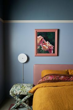 a bedroom with blue walls and yellow bedspread on the bed is decorated with pink flowers