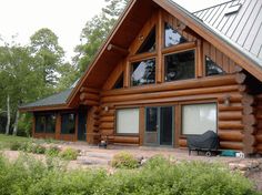 a log cabin with a covered patio and picnic table