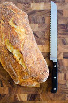 a loaf of bread sitting on top of a cutting board next to a knife