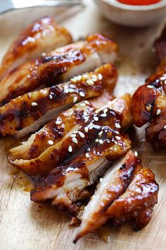 chicken wings with sesame seeds and ketchup on a cutting board