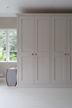 an empty room with white cupboards and a window