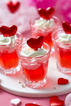 small cups filled with red liquid and topped with hearts