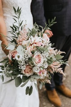 the bride and groom are holding their bouquets