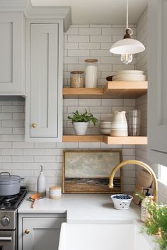 a kitchen with white cabinets and open shelves