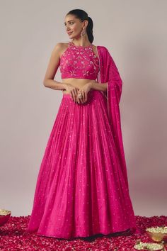 Fuchsia pink gathered flare lehenga with all over sequin bloom embroidery. Paired with a halter neck sleeveless blouse with floral bloom embroidery using sequins, pearls and thread highlights and a dupatta. - Aza Fashions Reka Bentuk Blaus, Lehenga Simple, Tiered Lehenga, Sleeveless Blouse Designs, Haldi Outfits, Crop Top Lehenga, Simple Lehenga