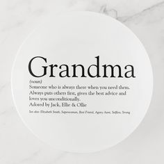 a white plate with the words grandma written in black on it, sitting on a marble surface