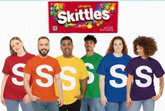 six people wearing skittles t - shirts in front of an advertisement for skittles