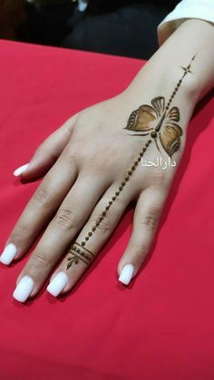 a woman's hand with hennap and cross tattoo on her left arm