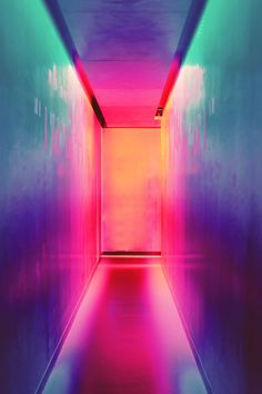 an empty hallway with red and blue light coming from the end to the other side