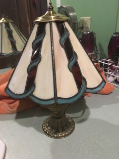 a lamp sitting on top of a table next to a mirror and other items in the background