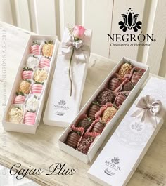 two boxes with different types of chocolates in them on a table next to each other