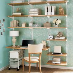 a desk with a laptop computer on top of it next to a shelf filled with books