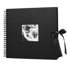 a black photo album with a bow on the front and back cover that has an image of a bride and groom