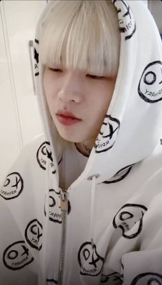 a person with blonde hair wearing a white hoodie