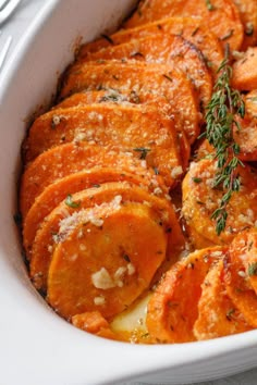 a casserole dish filled with sweet potatoes and topped with parmesan cheese