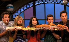 the cast of friends are holding sandwiches in front of them