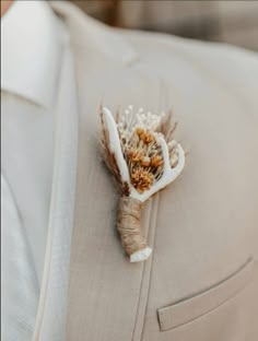 a boutonniere with dried flowers on the lapel of a man's suit