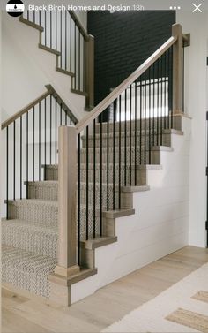 there is a black door and some stairs in the house with white carpet on the floor