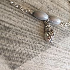 If you love spending your summer days at the beach, this fun summer seashell charm bracelet, with the cute conch shell charm and silver grey beads will be a wonderful reminder of happy days spent among the seashells. The delicate beach themed silver plated chain is light and small enough to wear on a daily basis, and will look great layered with other bracelets. Click here for more bracelet designs to layer up for a fun summer style! It would make a fun seaside gift idea for anyone you know who Silver Shell For Beach With Ocean-inspired Style, Silver Beaded Jewelry For Beach, Nickel-free Sterling Silver Bracelets For The Beach, Beach Jewelry With Silver Pearl Charm, Beach Jewelry: Silver With Pearl Charm, Silver Beach Jewelry With Pearl Charm, Beach Silver Jewelry With Pearl Charm, Silver Ocean-inspired Bracelets For Beach, Trendy Silver Shell Jewelry With Oyster Bracelet