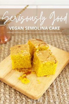 a wooden cutting board topped with two pieces of vegan semollina cake