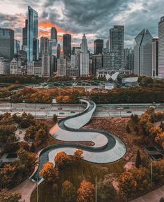 an aerial view of the chicago skyline with a river running through it and trees in the foreground