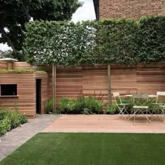 a backyard with wooden walls and green grass