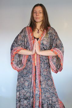 "*◅ ↠ ॐ ☽ ◅* Namaste *▻ ☾ ॐ  *◅ ☽ Anahata Kimono ☾ ▻* in Charcoal Rust Our silk kimonos are handcrafted & designed in India using Saree silks  Featuring long flared sleeves & detachable tie belt for extra shape.  Wear open and billowing or synch in at the waist. Perfect for any season! Cover up by the beach or add a pop of colour to your Winter wardrobe. The silk is surprisingly warm; holding in heat while simultaneously airy.  Team with skinny jeans or over some flares for an effortlessly Bohemian dream look. *PLEASE NOTE* Each and every one of our beautiful kimonos are made by hand. The same material is used for each piece, however, there may be small differences in the positioning of the print. This is an addition to the charm of each kimono, since they are all truly unique.  *◅ ↠ ॐ ☽ ◅ Orange Long Sleeve Kimono For Festivals, Fitted Bohemian Wrap Kimono, Bohemian Orange Wrap Kimono, Fitted Bohemian Kimono For Festivals, Fitted Red Bohemian Kimono, Fitted V-neck Bohemian Kimono, 70s Festival, Silk Wrap Top, Boho Robes