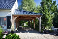 an outdoor covered walkway with potted plants and trees in the backgrouf