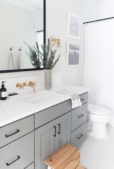 a white and gray bathroom with wooden stool