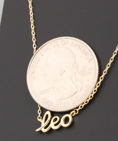 a gold necklace with the word leo on it