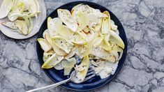 a blue plate topped with apple slices next to a fork