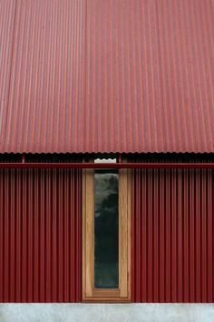 a red building with a wooden door and window