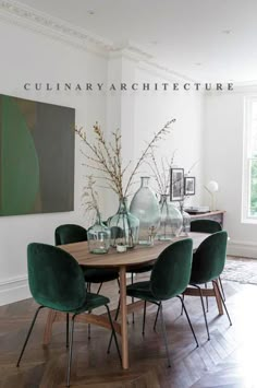 a dining room table with green chairs and vases