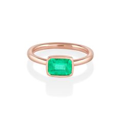 a rose gold ring with an emerald stone