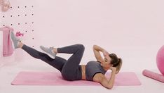 a woman in grey top and gray pants doing exercises on pink mat with exercise balls