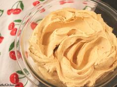 a glass bowl filled with peanut butter on top of a tablecloth covered table cloth