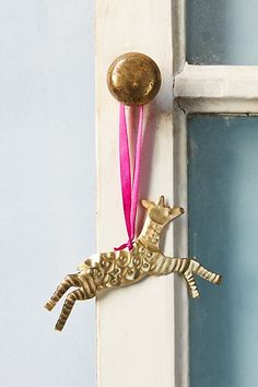 a door handle with a giraffe decoration hanging from it's side, next to a window