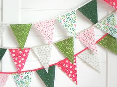 the bunting is decorated with many different colors and patterns, including red, green, white, and pink