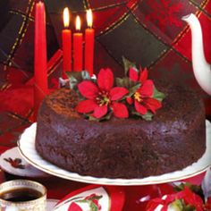 a chocolate cake sitting on top of a white plate next to a cup of coffee