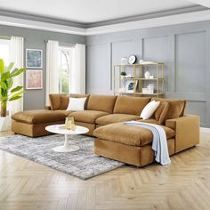 a living room with a large sectional couch and coffee table in front of a window