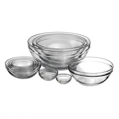 an assortment of glass bowls and plates on a white background