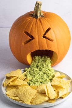 a pumpkin with its mouth open and chips in front of it