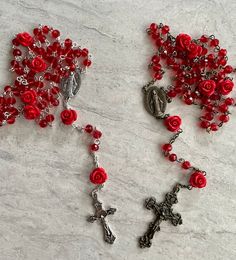 a rosary with red roses on it and a crucifix in the middle