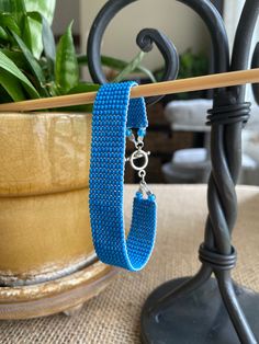 a pair of blue bracelets sitting on top of a table next to a potted plant